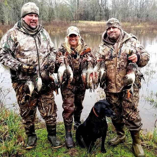BigWoods duck hunters with their harvest beside flooded timber